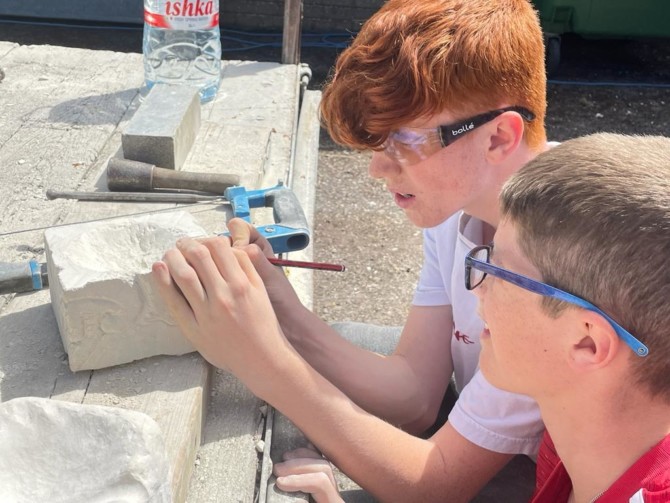 Boys working on stone carving piece Boys working on stone carving piece